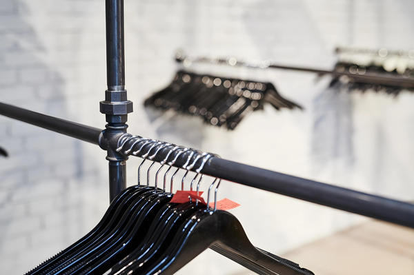 Aménagement intérieur sur mesure d'une salle de spectacle avec des solutions de vestiaire en tuyaux d'eau bruts.