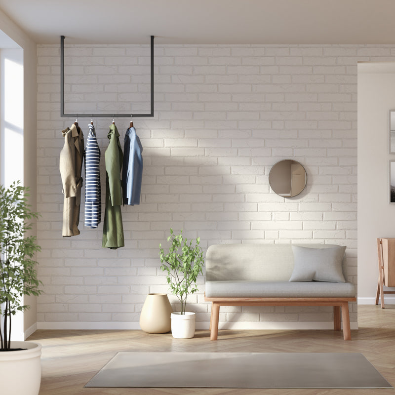 Tringle à vêtements minimaliste noire suspendue au plafond dans l'entrée de la maison
