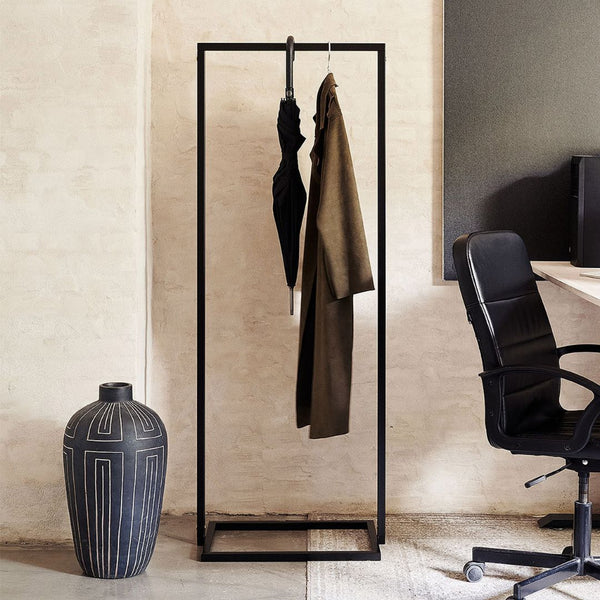 Portant à vêtements noir avec socle carré pour accrocher les manteaux et parapluie dans un bureau