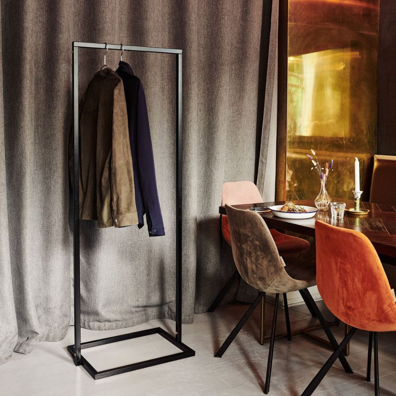 portemanteau étroit noir mat avec socle carré pour accrocher les vestes dans un restaurant