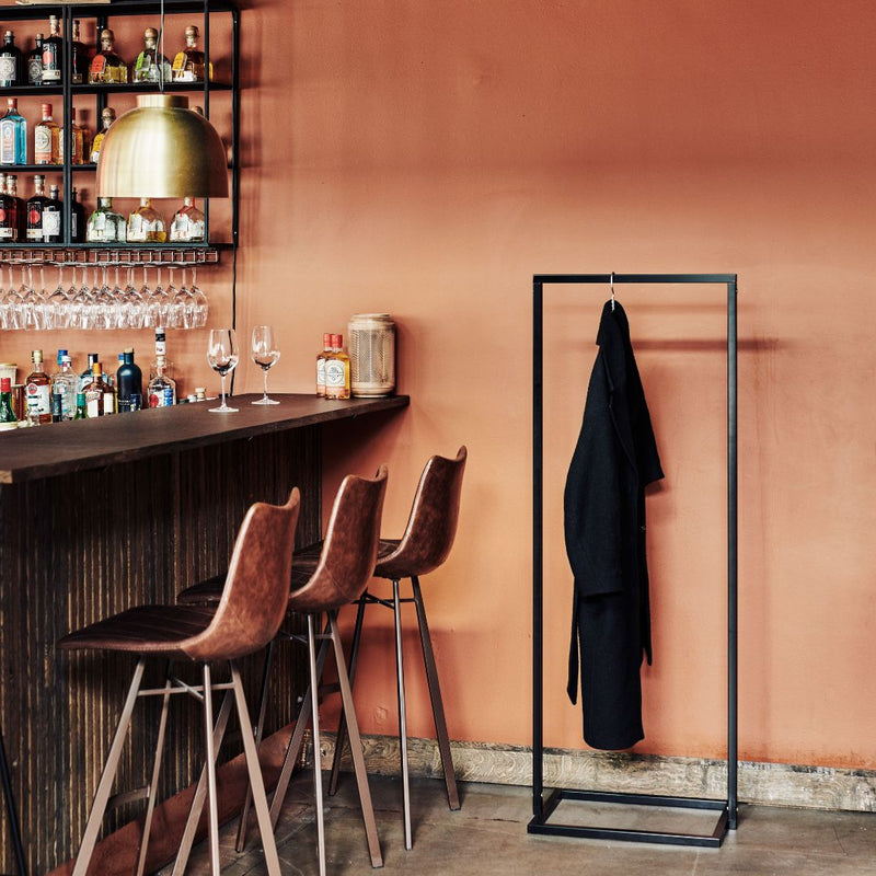 Portant à vêtements noir avec socle carré pour accrocher les manteaux dans un restaurant