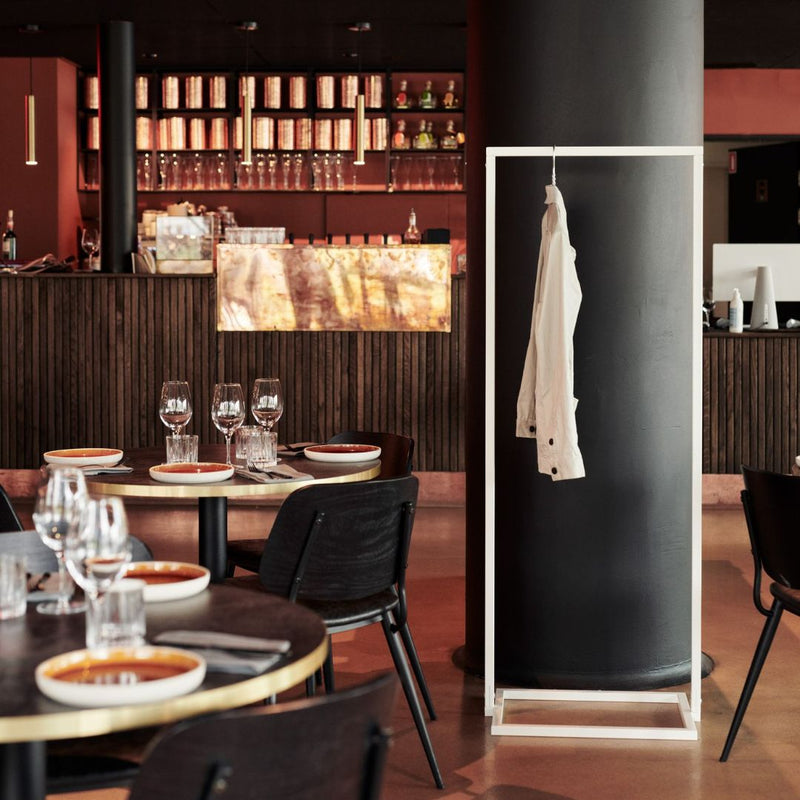 Portant à vêtements blanc avec socle carré pour un restaurant