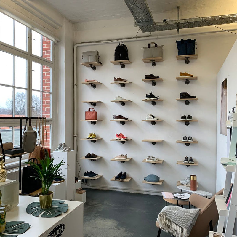 petites étagères en pin clair pour ranger les paires de chaussures dans une boutique 