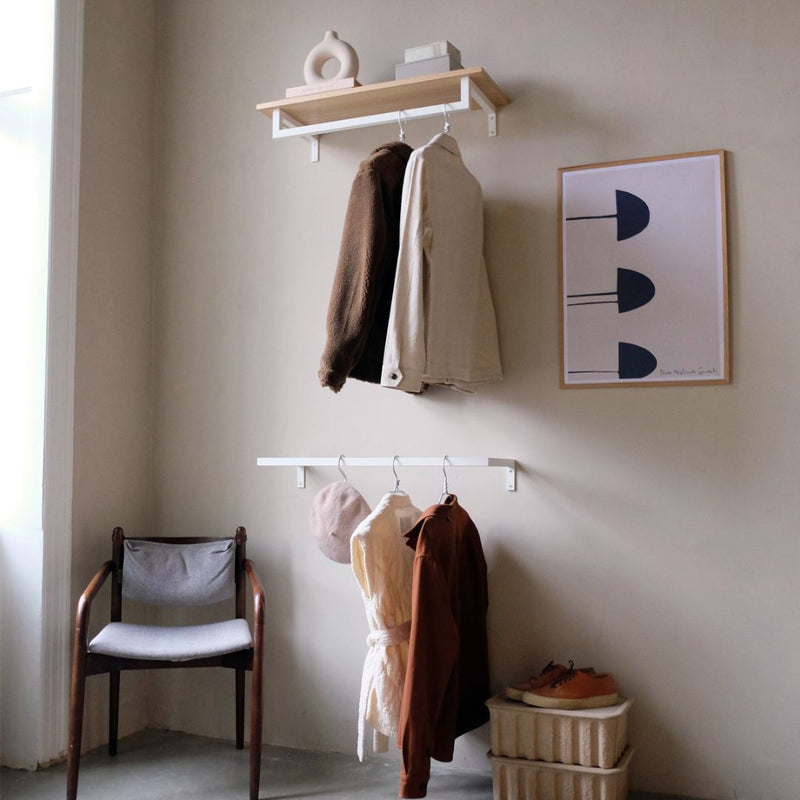 étagère en chêne classique équipée d'une tringle à vêtements minimaliste blanc mat pour accrocher les vêtements et ranger les accessoires dans l'entrée