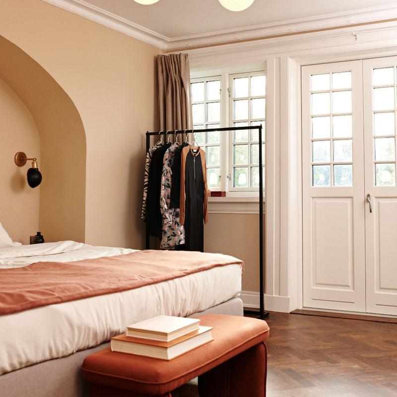 Portemanteau minimaliste noir avec socle carré pour une chambre à coucher 