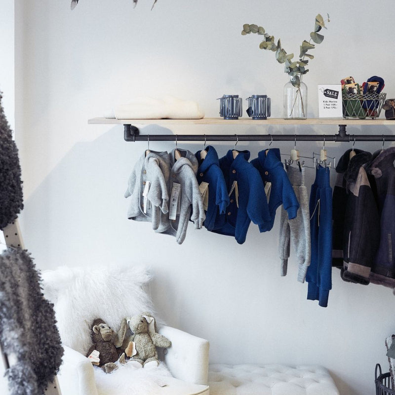 étagère murale avec tringle à vêtements intégrée pour boutique de vêtements d'enfant