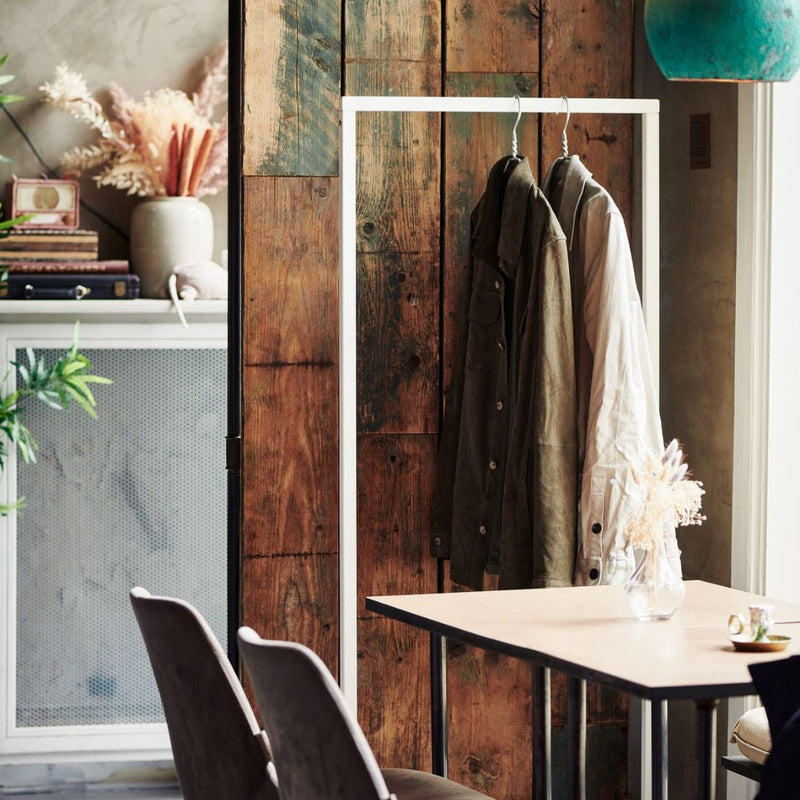 Portant à vêtements blanc avec socle carré pour accrocher les vestes dans un bar restaurant