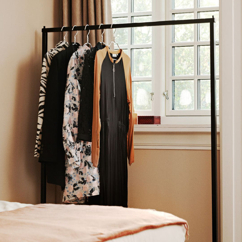 Portant à vêtements minimaliste noir pour accrocher chemises et robes 